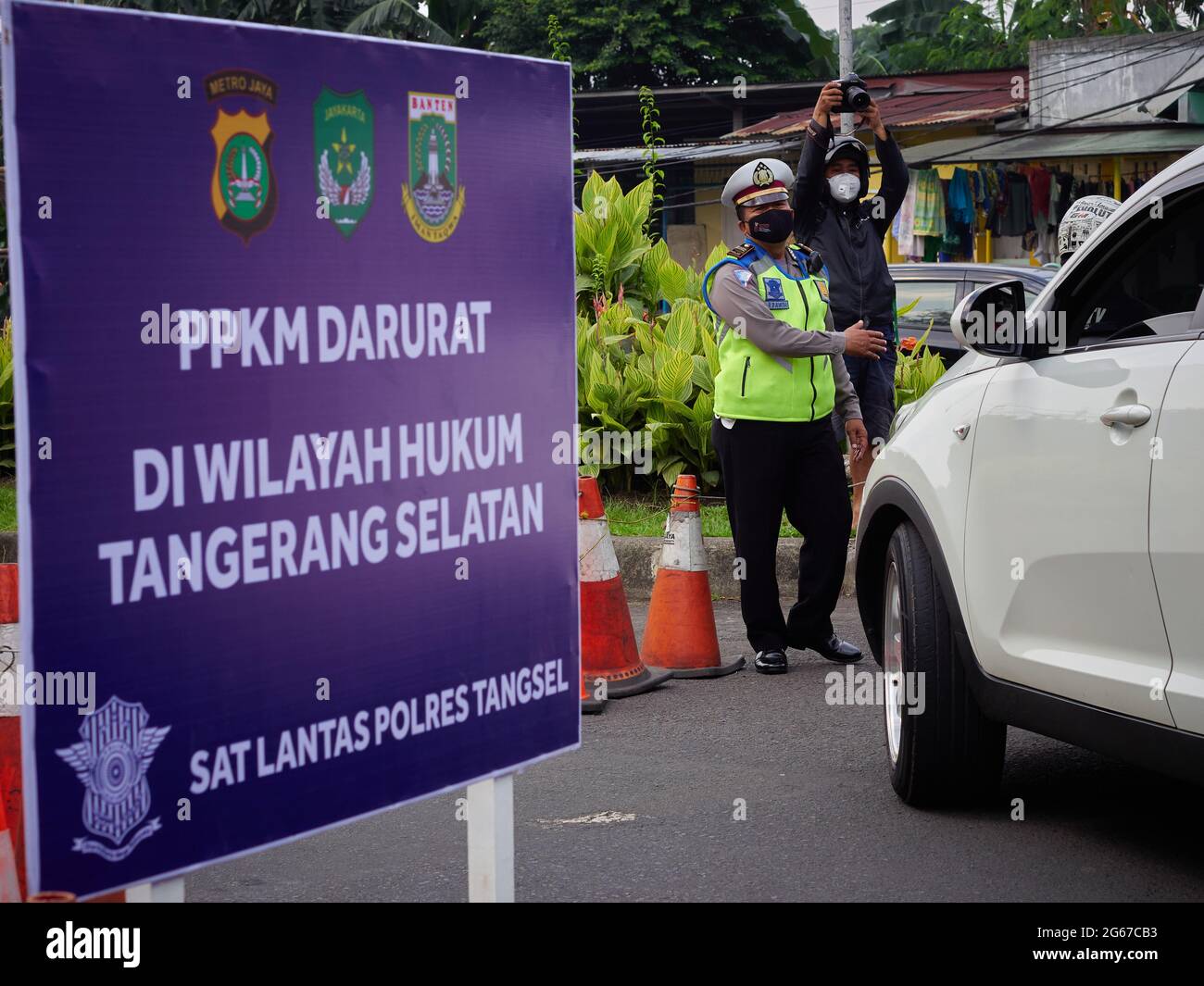 Police officers close the access to Jakarta at Bintaro Utama street, South  Tangerang, as an effort to support Stricter Social Restrictions. A number  of vehicles were forced to turn around. This policy