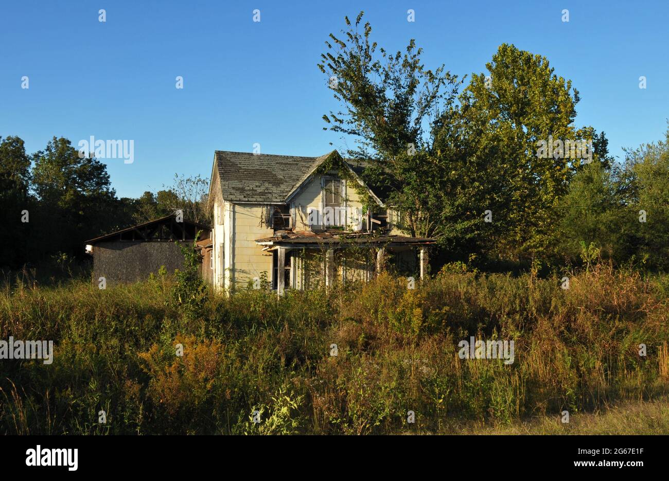 An abandoned home stands on an overgrown rural property along Route 66 near Warwick, Oklahoma. Stock Photo