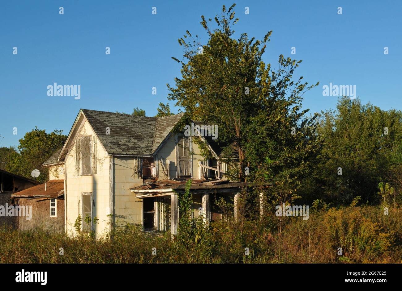An abandoned home stands on an overgrown rural property along Route 66 near Warwick, Oklahoma. Stock Photo