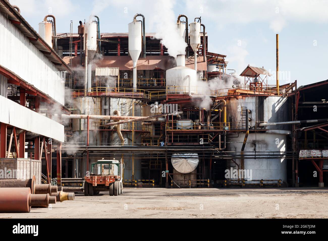 External view of a sugar refinery with piping, cooking vats and vapour Stock Photo