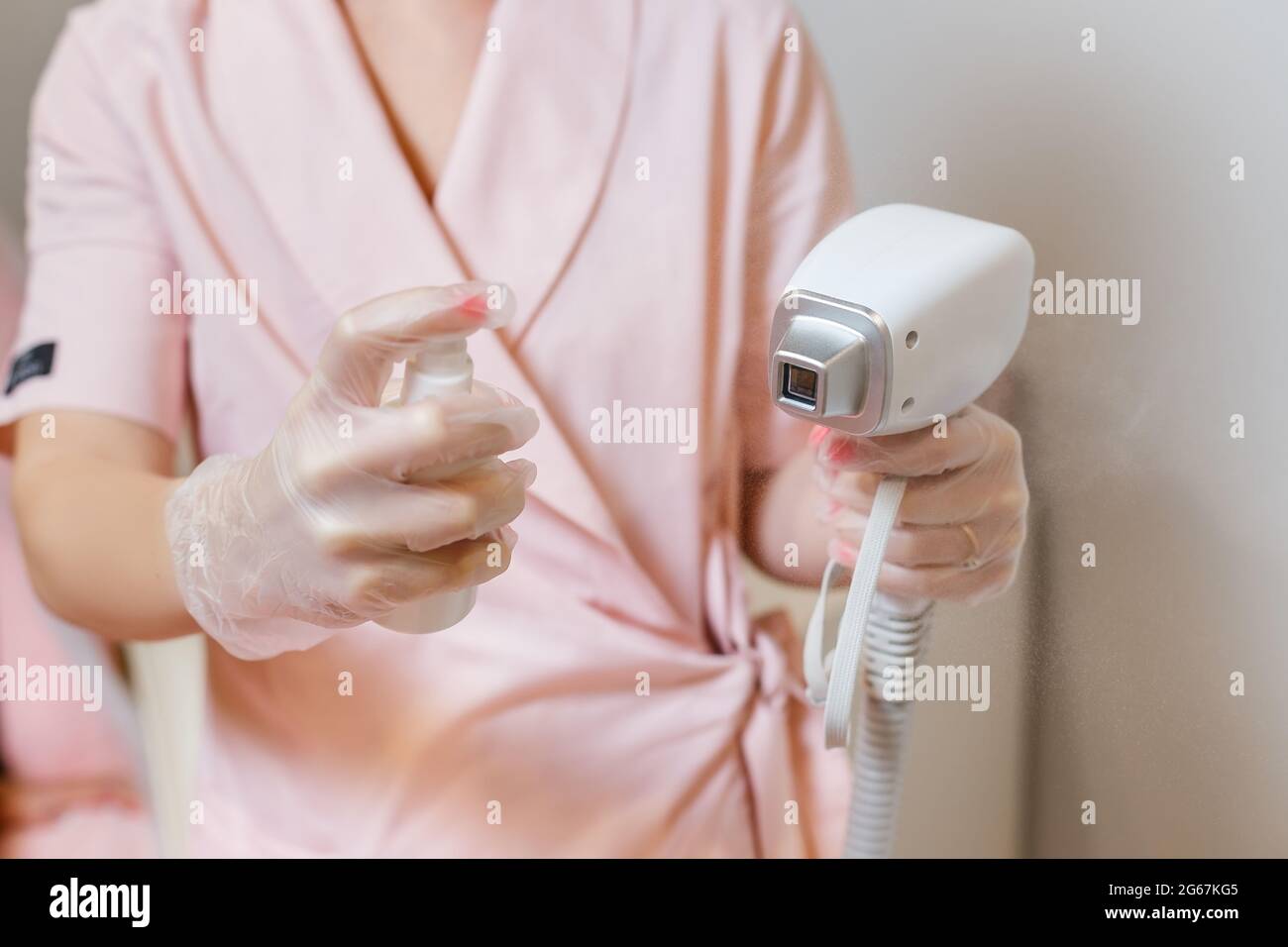 Laser hair removal equipment disinfection. Cosmetologist cleaning laser