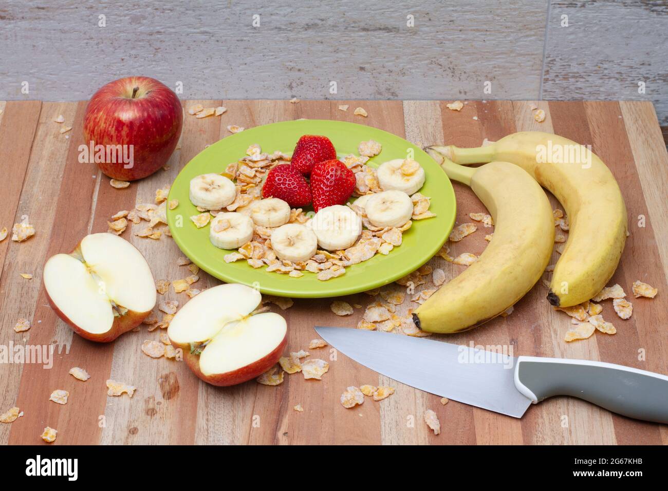 Red apple, sliced banana, strawberry berries and cereals Stock Photo