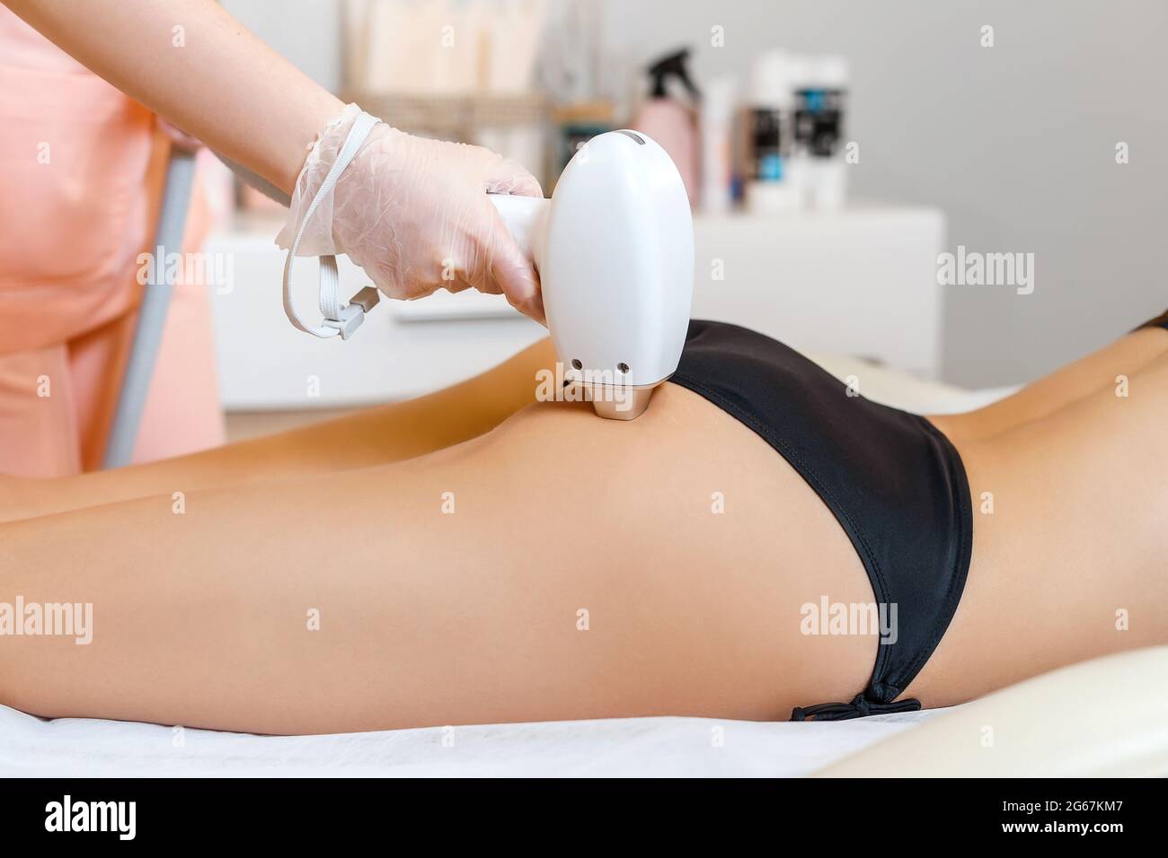 Laser hair removal in action. Cosmetologist making laser epilation on young  woman buttocks. Close-up maniple in spa salon Stock Photo - Alamy