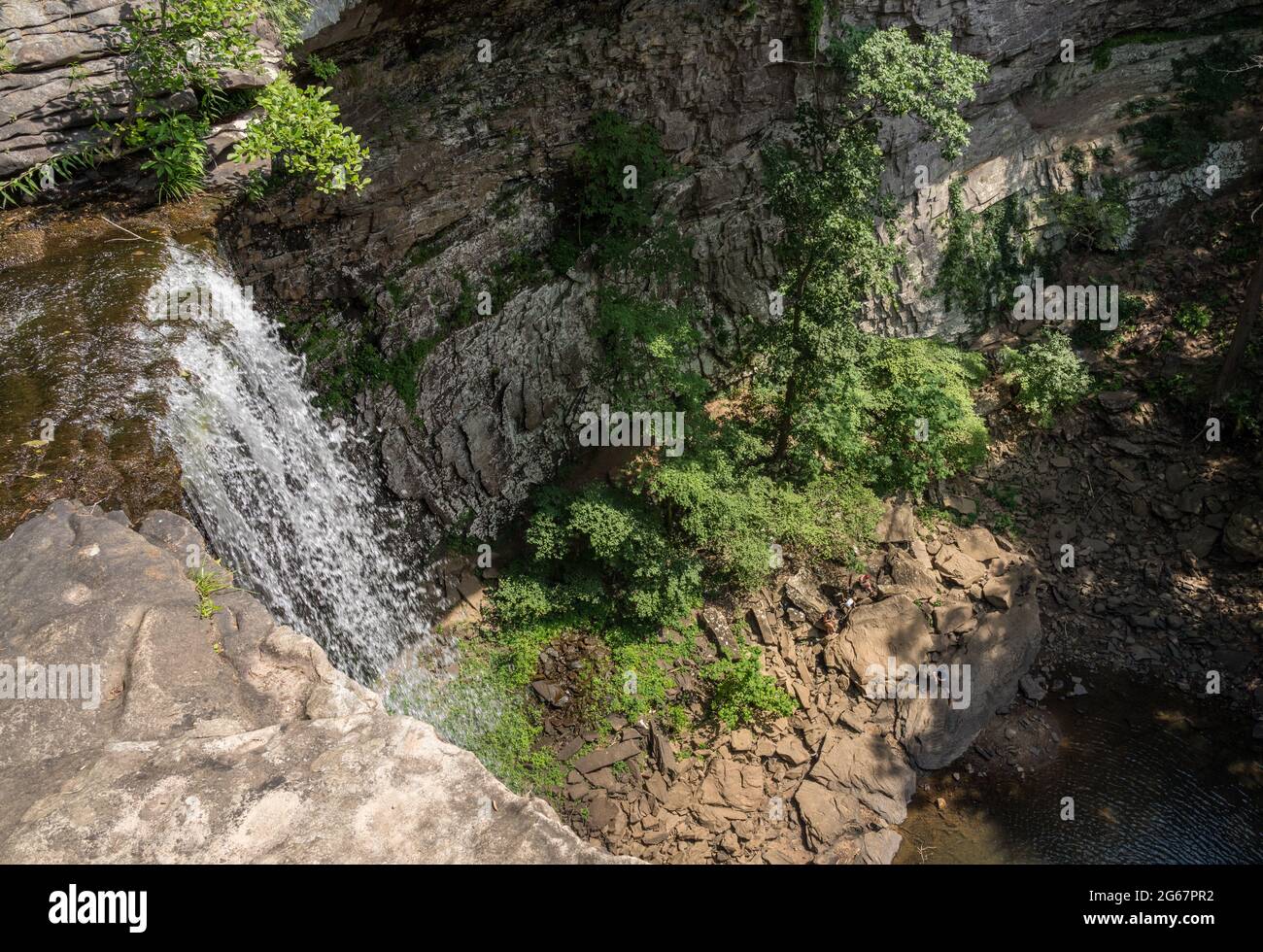 Water flowing over the cliff edge at Ozone falls in Tennessee as the water flows into the pool below Stock Photo