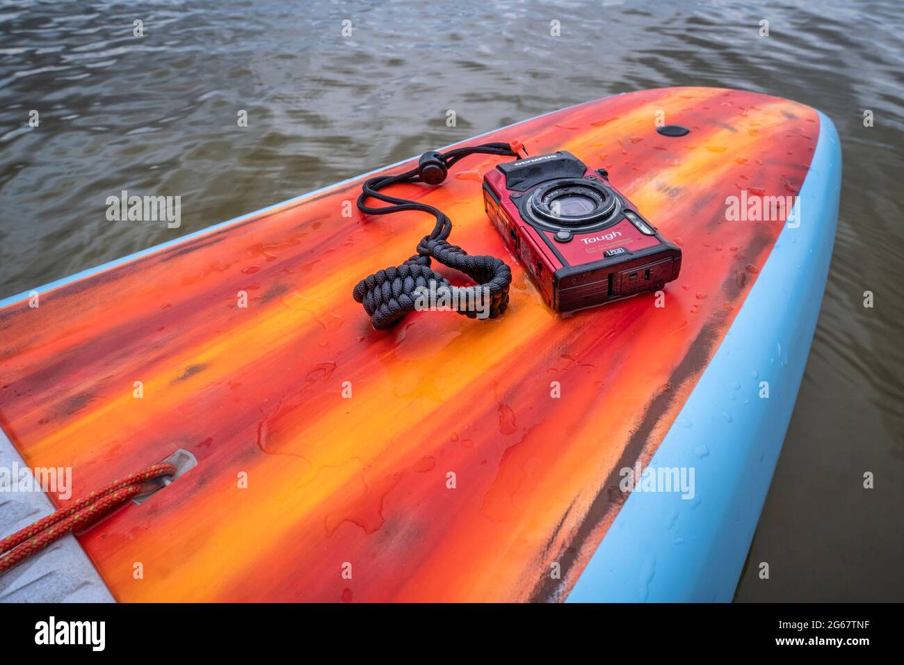 Fort Collins, CO, USA - May 9, 2021: Compact, waterproof Olympus Stylus Tough TG-5 camera on a rear deck of a stand up paddleboard by Mistral. Stock Photo