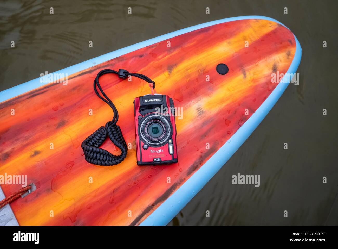 Fort Collins, CO, USA - May 9, 2021: Compact, waterproof Olympus Stylus Tough TG-5 camera on a rear deck of a stand up paddleboard by Mistral. Stock Photo