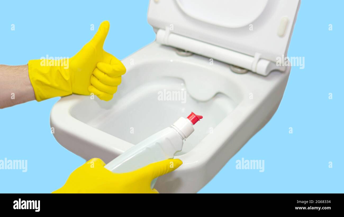 White toilet bowl in the interior, modern toilet. Disinfection of the toilet, cleaning the toilet, washing away dirt from the toilet, flushing away Stock Photo
