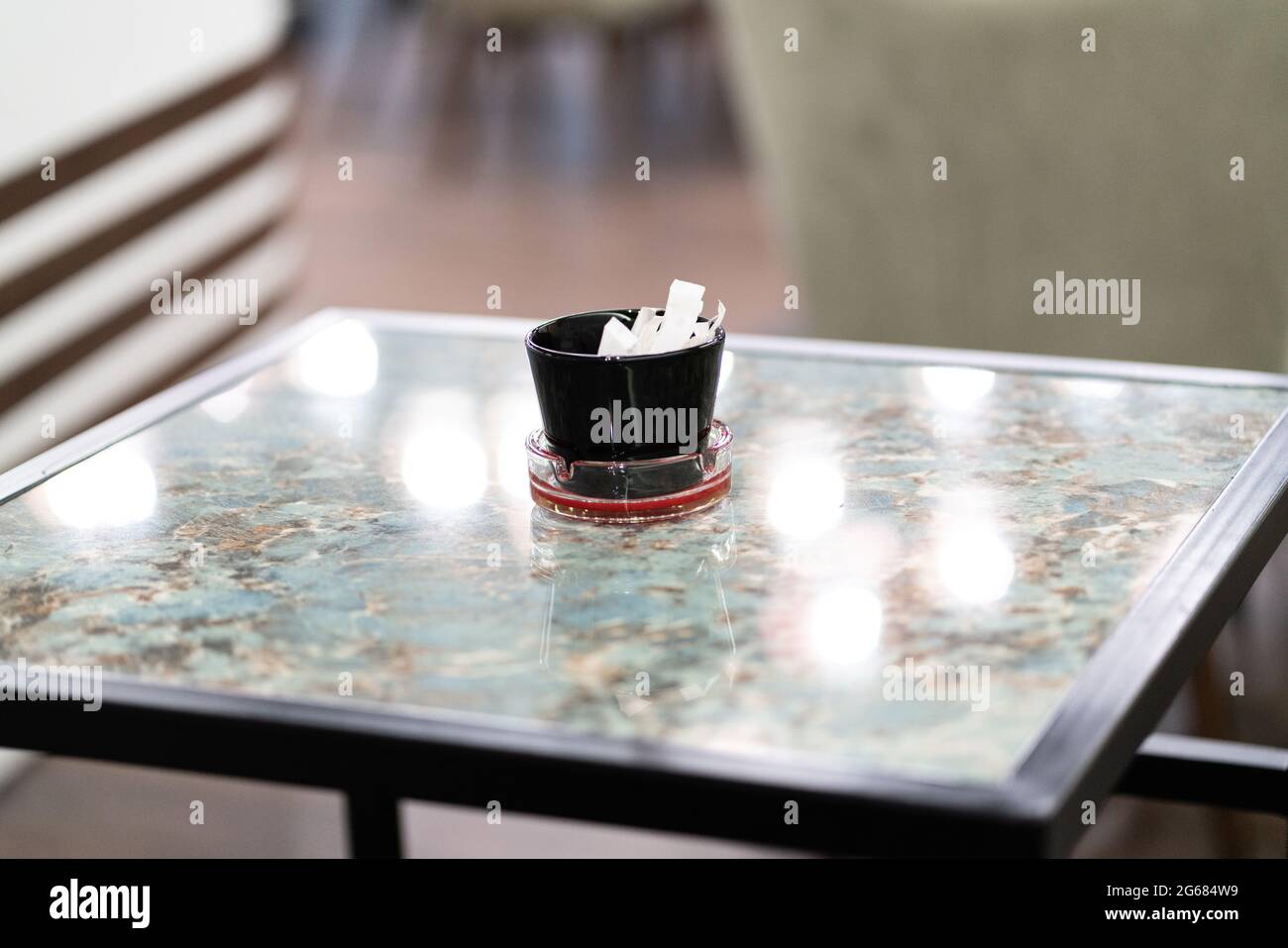 Packaging Sachet Of Sugar Stick Standing On Table Stock Photo