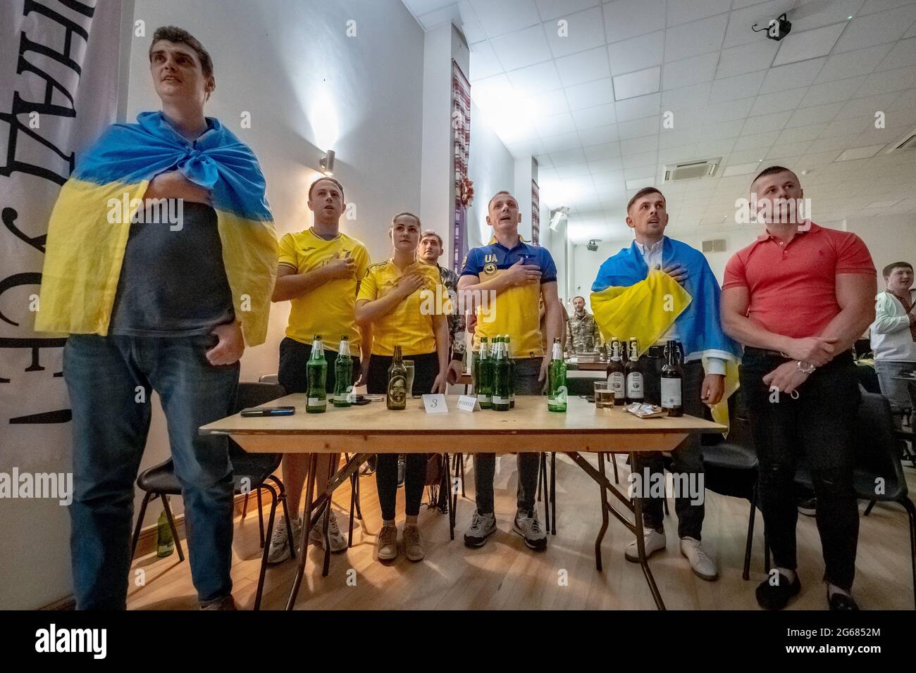 London, UK. 3rd July, 2021. UEFA EURO 2020: Ukraine vs England. British-Ukrainians stand for their national anthem prior to kick-off at the Association of Ukrainians in Great Britain venue (AUGB) in Holland Park. Credit: Guy Corbishley/Alamy Live News Stock Photo