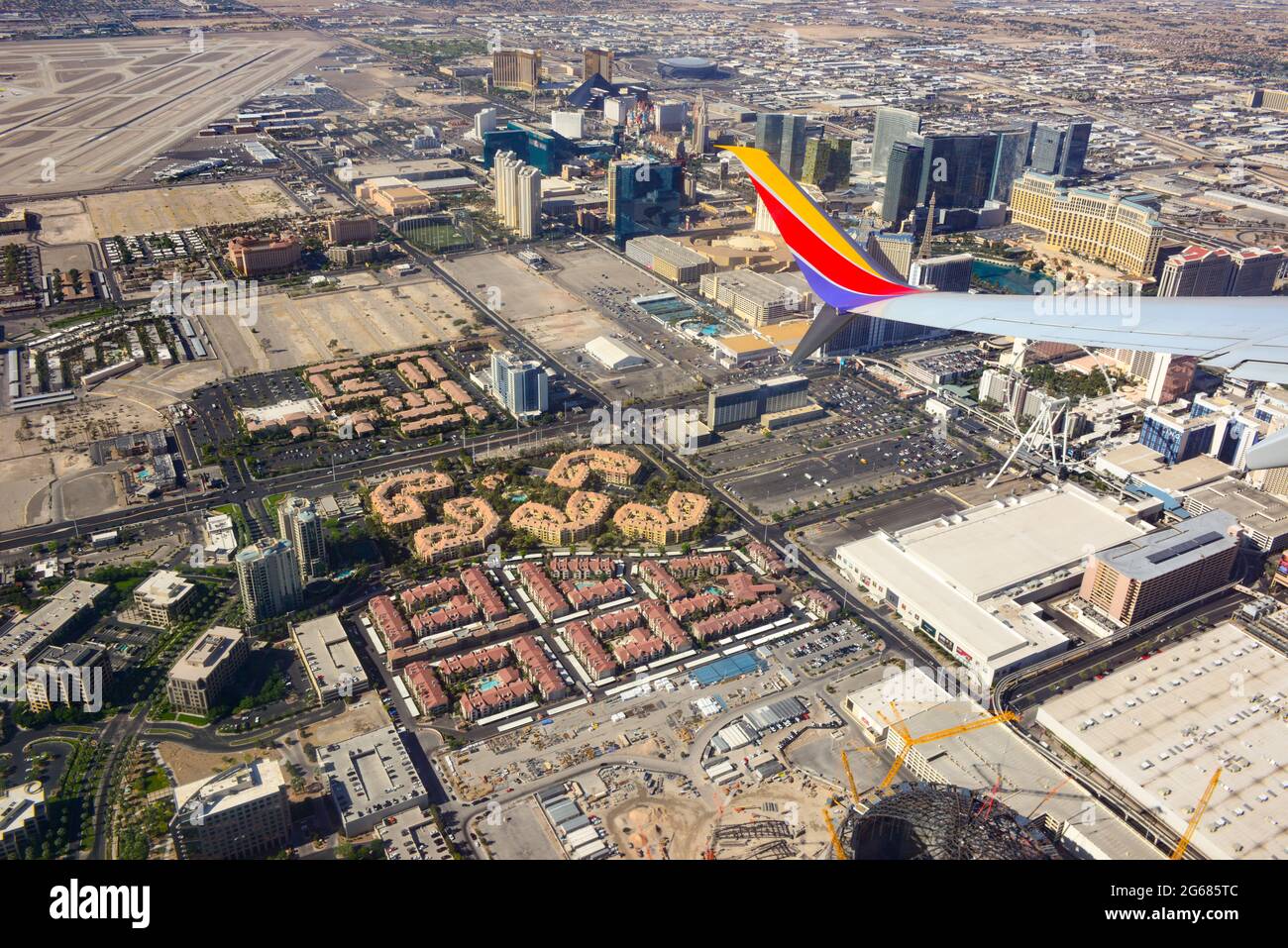 A jet wing tip of an 780 Max airplane in the foreground of an aerial view of the  Vegas strip area soon after liftoff from Las Vegas McCarran Internat Stock Photo