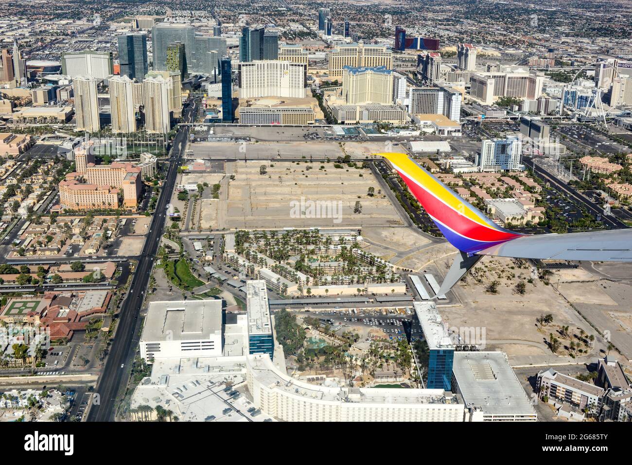 A jet wing tip of an 780 Max airplane in the foreground of an aerial view of the  Vegas strip area soon after liftoff from Las Vegas McCarran Internat Stock Photo