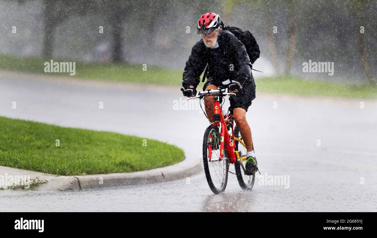 A bicyclist rides through rain along Flamingo Road in Sunrise, Florida, on July 1, 2021. South Florida remains within range of Tropical Storm Elsa, which could affect the region early next week as a tropical storm. (Photo by Carline Jean/South Florida Sun Sentinel/TNS/Sipa USA) Credit: Sipa USA/Alamy Live News Stock Photo