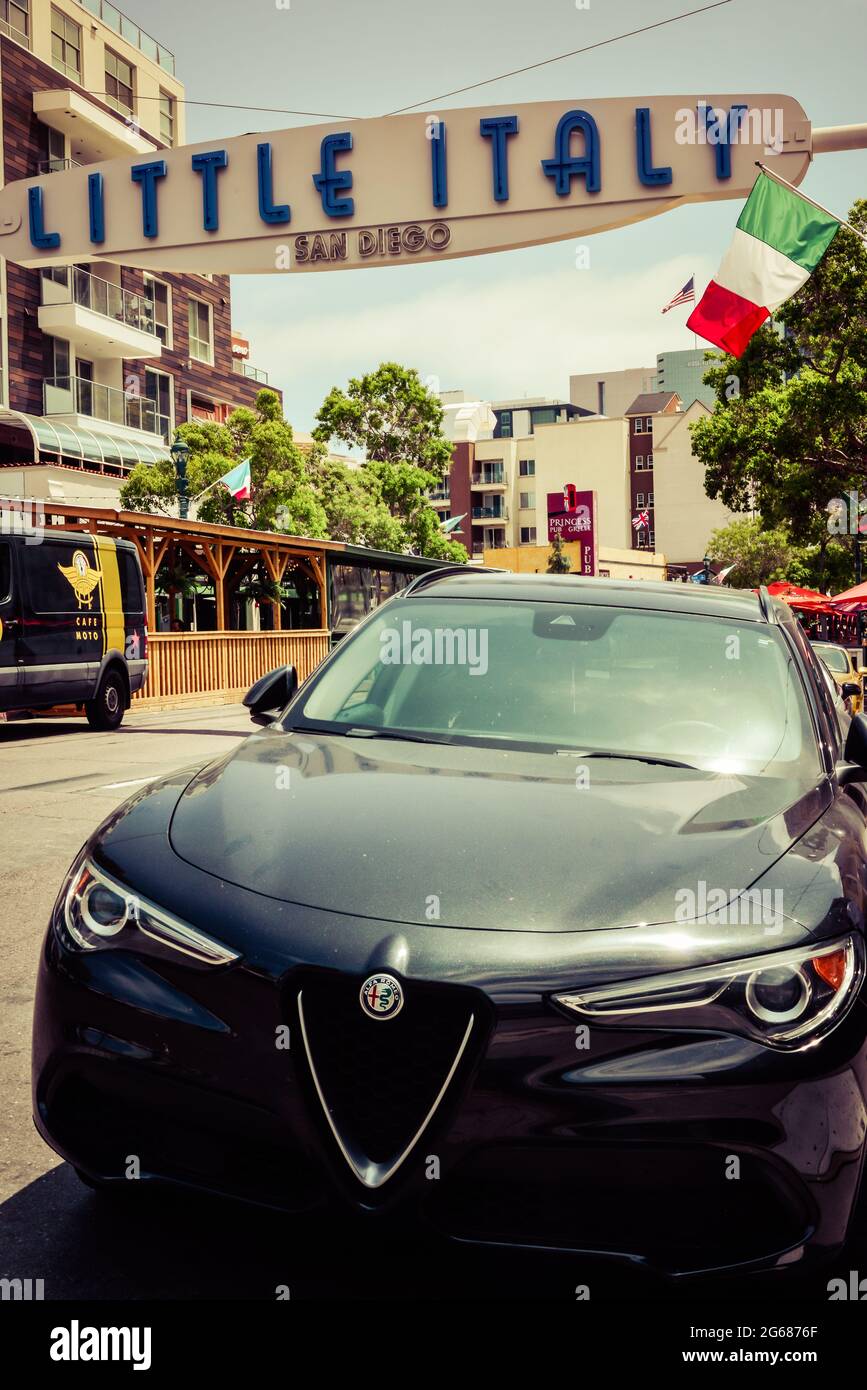 Close up of a late model Alpha Roma Giulia car parked under the overhead sign for Little Italy neighborhood near the waterfront in San Diego, CA, USA Stock Photo