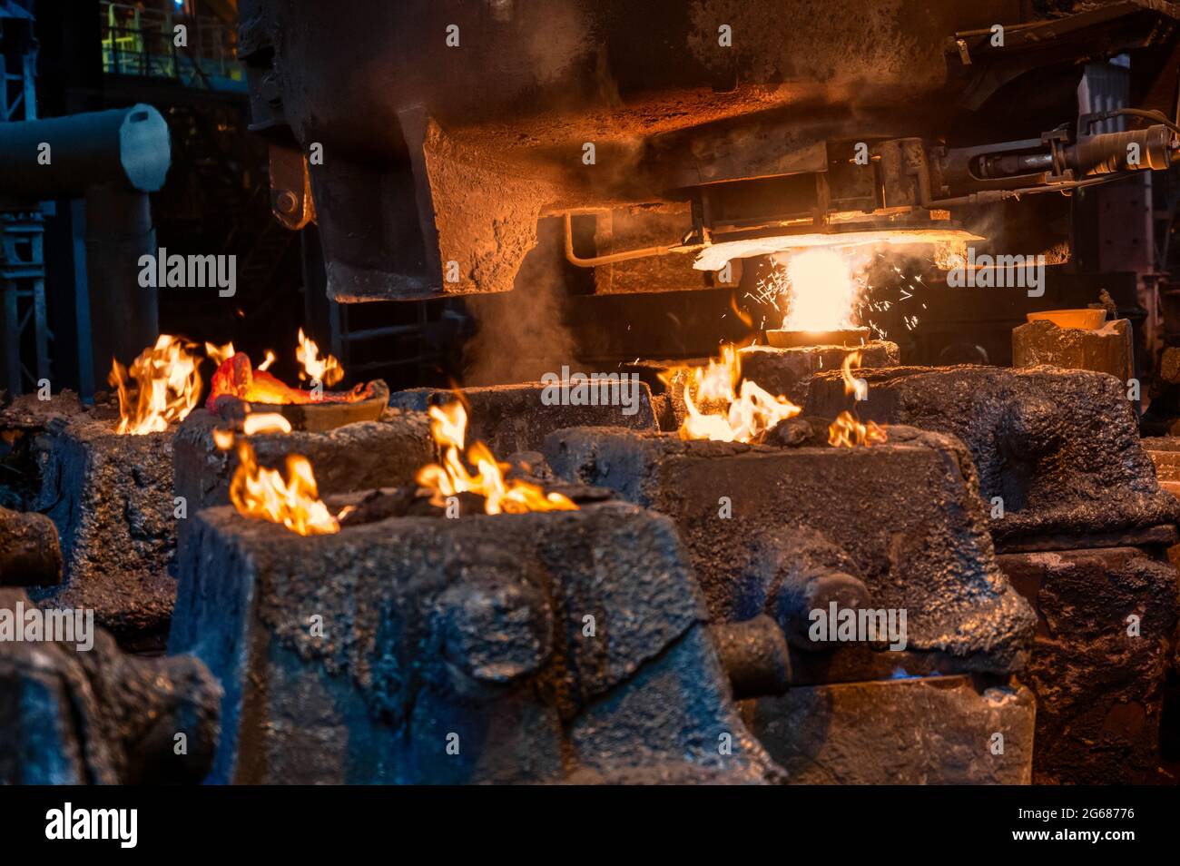 Steel molds for metal pouring. A fire burns at the top of the molds Stock Photo