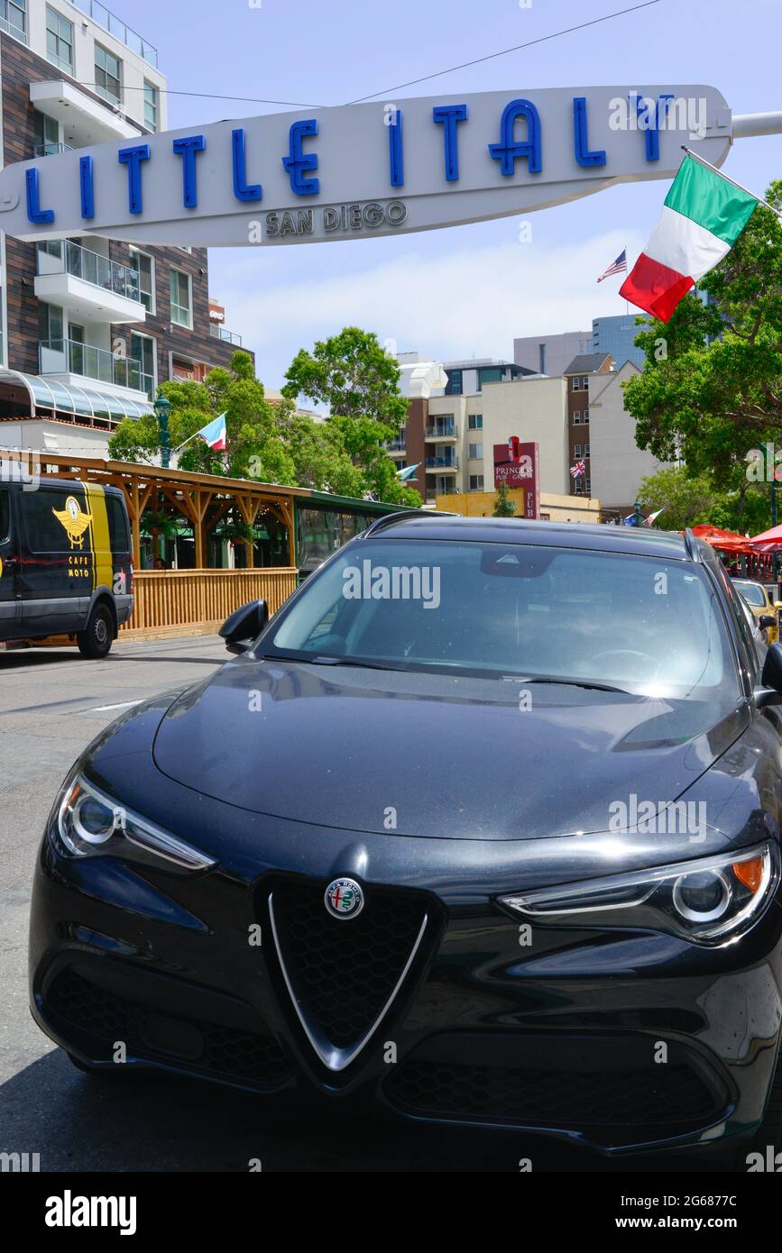Close up of a late model Alpha Roma car Giulia parked under the overhead sign for Little Italy neighborhood near the waterfront in San Diego, CA, USA Stock Photo