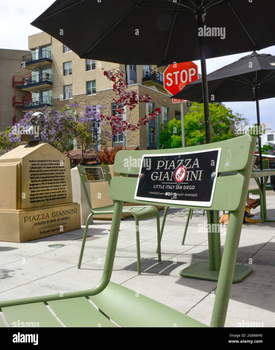 A green metal patio chair with signage for Piazza Giannini, (Note no fur sticker) Amadeo Giannini, honored banker with nearby statue in San Diego, CA Stock Photo
