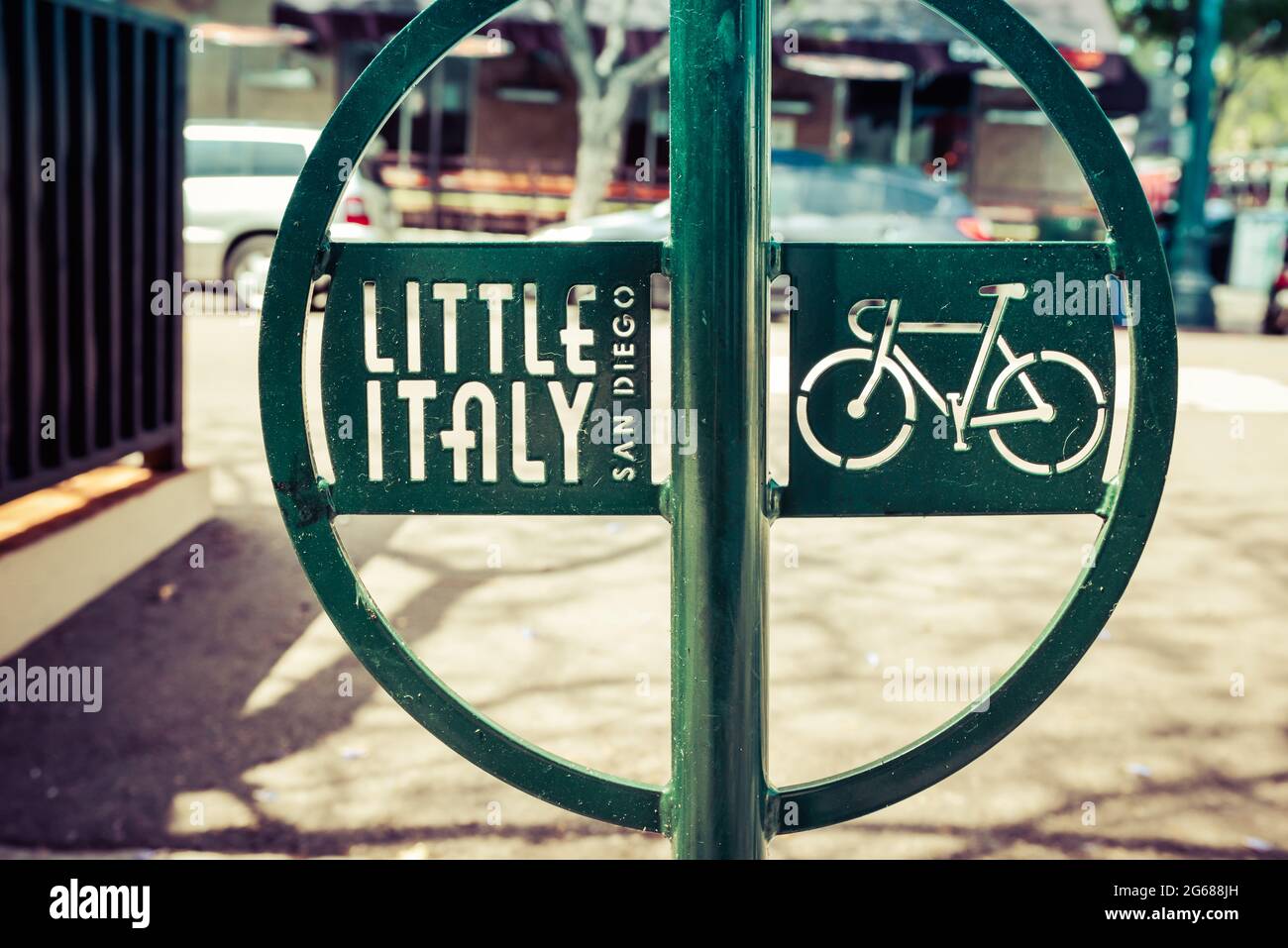 Close up of a modern green metal bike rack with Little Italy logo and cut out art of bicycle on sidewalk near the harbor in San Diego, CA Stock Photo