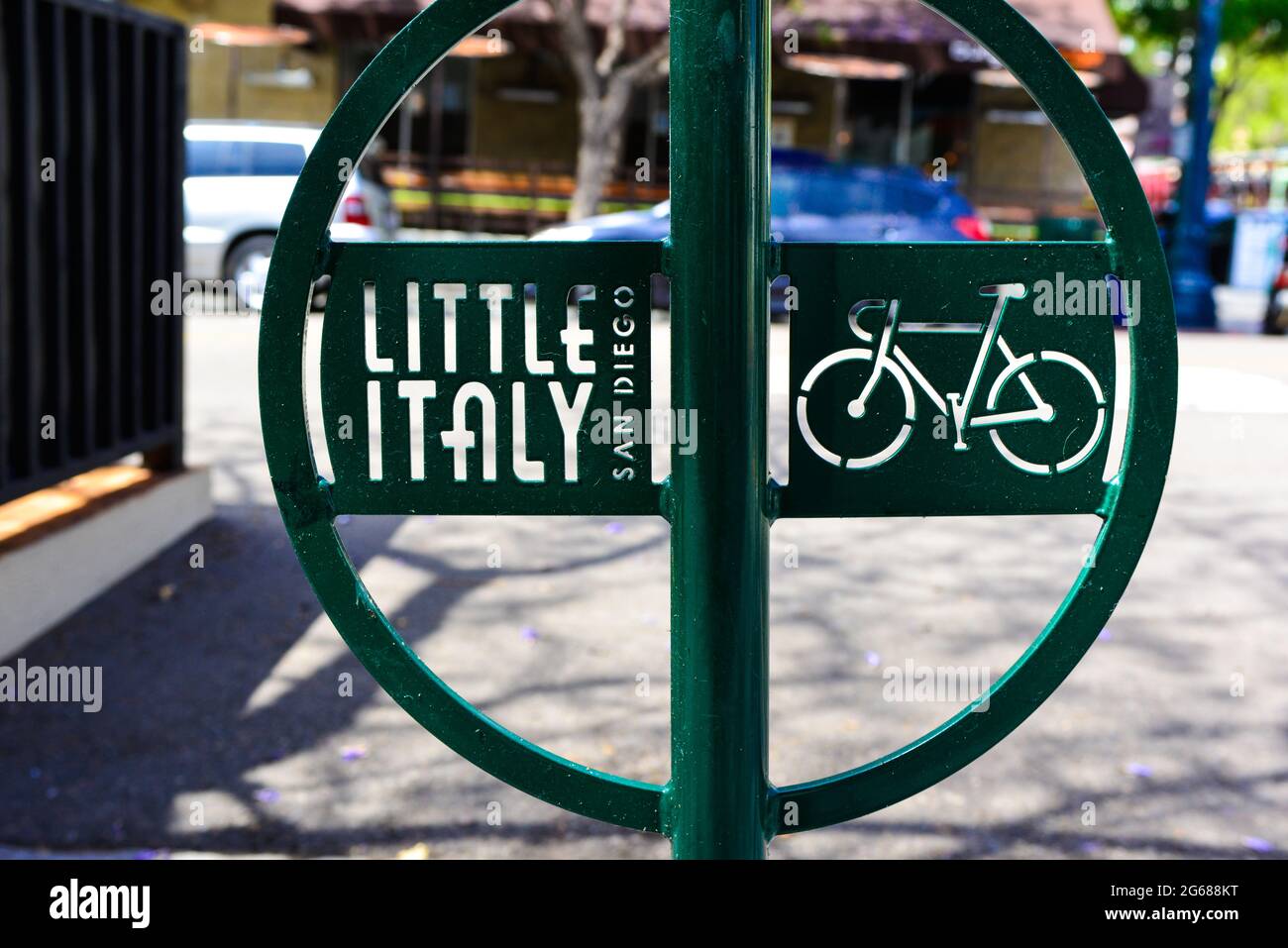 Close up of a modern green metal bike rack with Little Italy logo and cut out art of bicycle on sidewalk near the harbor in San Diego, CA Stock Photo