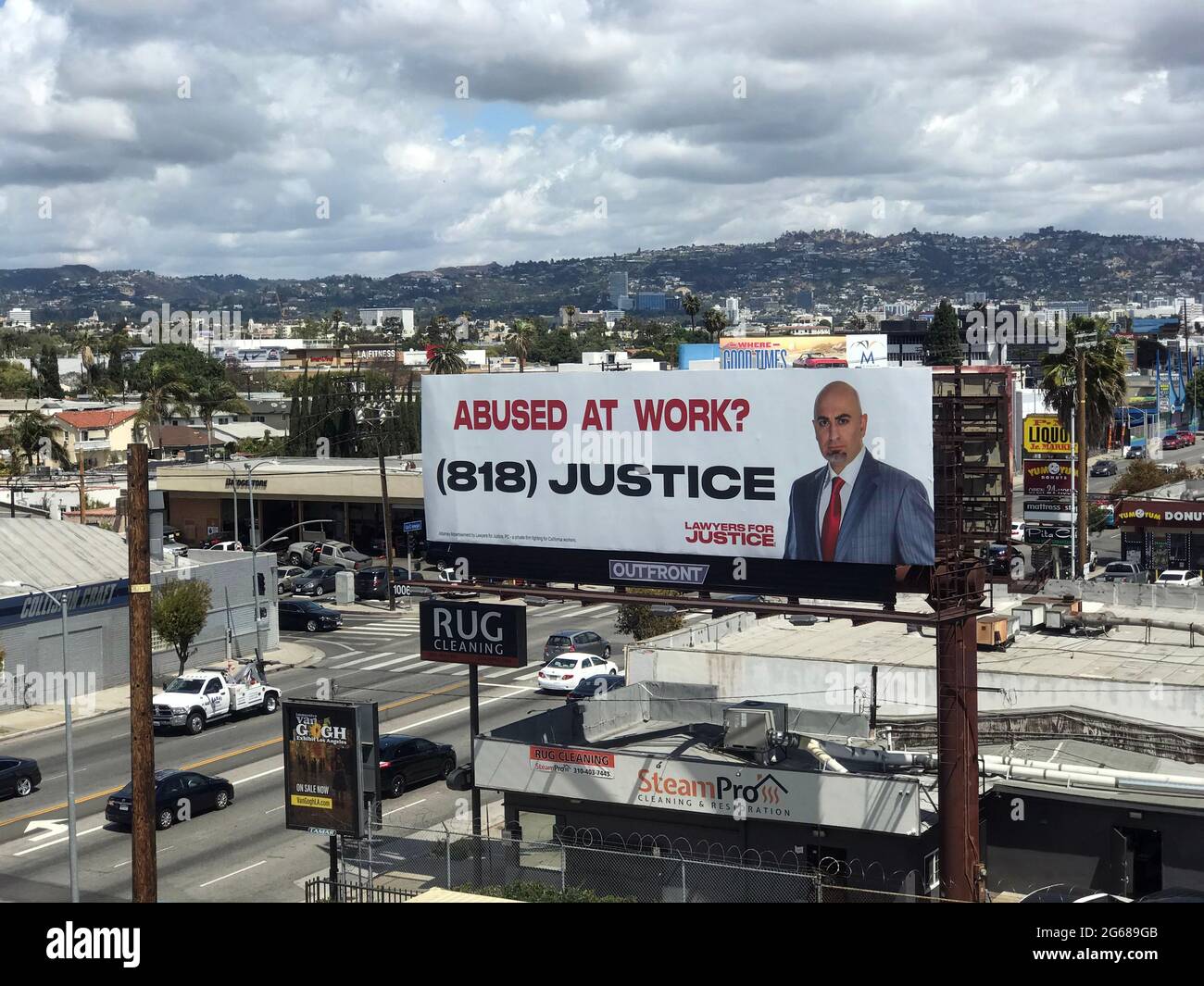 Billboard in Los Angeles urban landscape advertising legal services for abuse at work. Stock Photo
