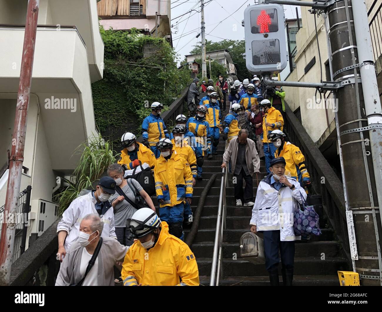 Shizuoka, Japan. 4th July, 2021. Rescuers help to transfer local citizens after a mudslide in Atami, Shizuoka prefecture, Japan, July 4, 2021. Two people were dead and about 20 others remained missing on Saturday following a massive mudslide triggered by torrential rain in central Japan, local authorities said. Credit: Hua Yi/Xinhua/Alamy Live News Stock Photo