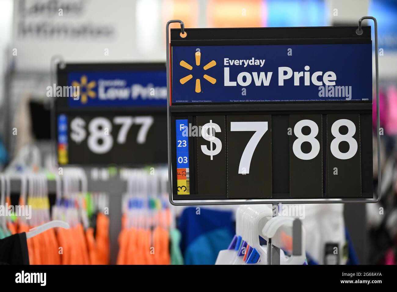 Walmart Everyday Low Price Sign on Clothing Rack, Price of '$7.88' (foreground) and '$8.77' (background), Right Side, Clothes Hangers Visible. Stock Photo