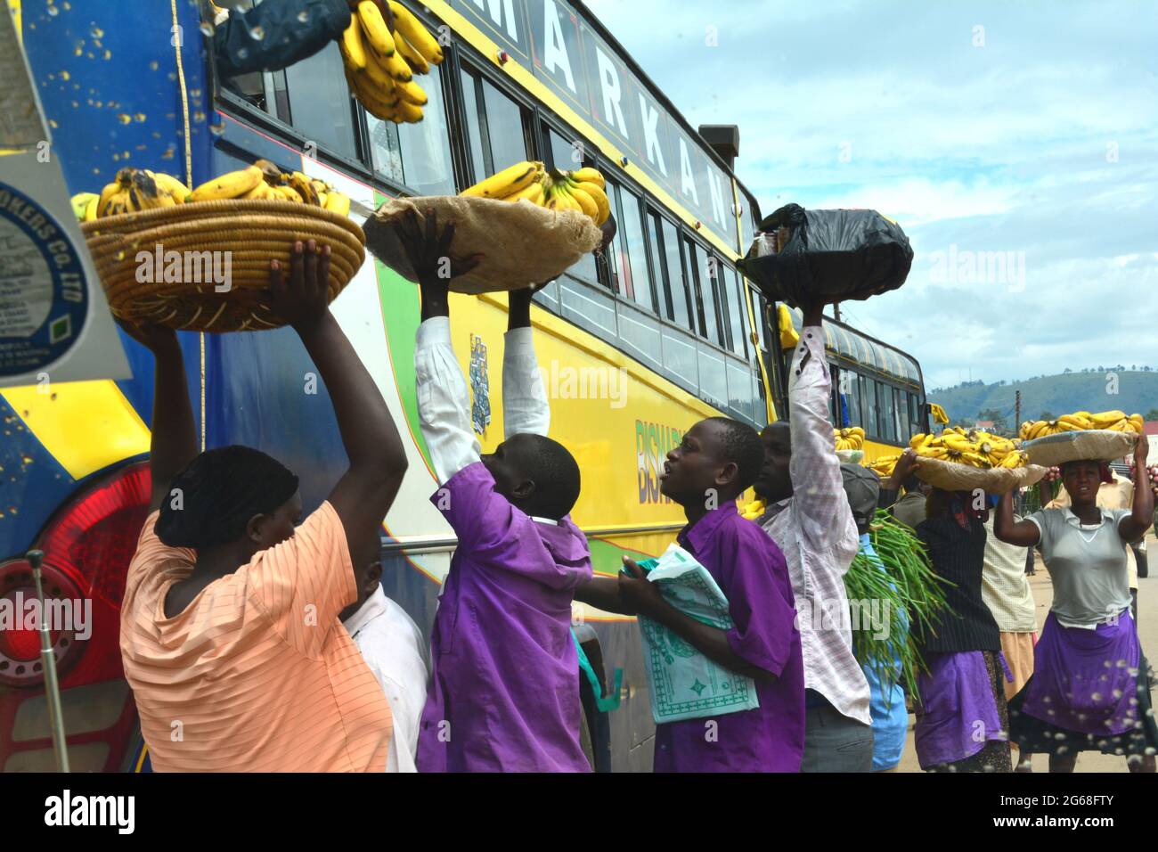 UGANDA. WOMEN AND MEN SELLING FRUITS AND VEGETABLES SELLING ON THE ROAD. Stock Photo