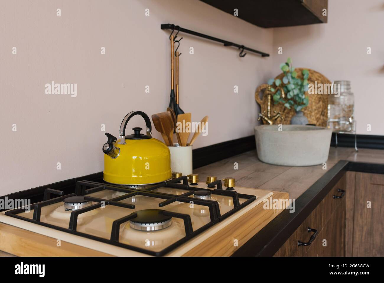 Yellow kettle on a gas stove in the wooden kitchen of a country house