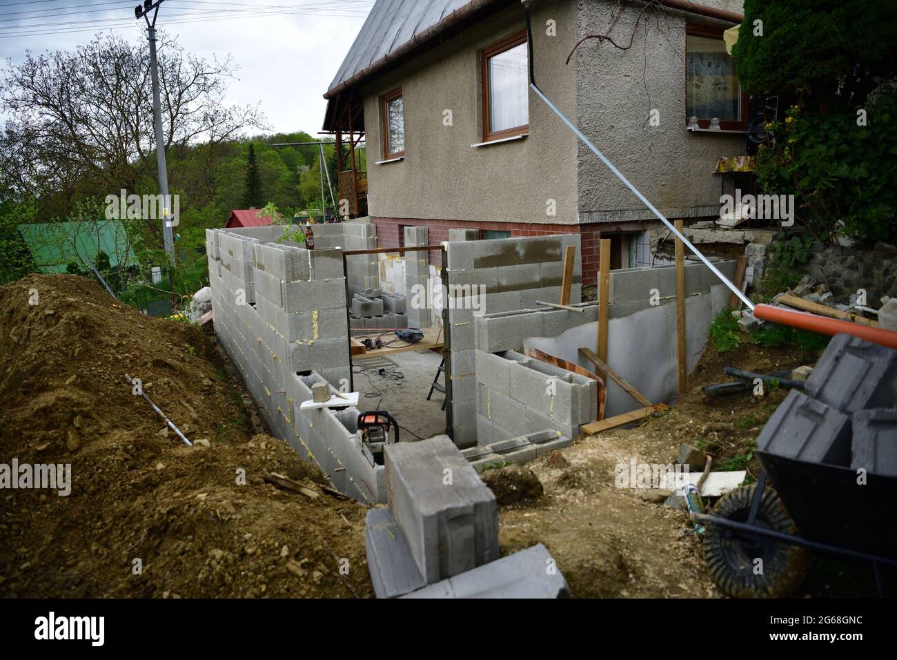 Extension of the walls of prefabricated blocks to the existing cottage
