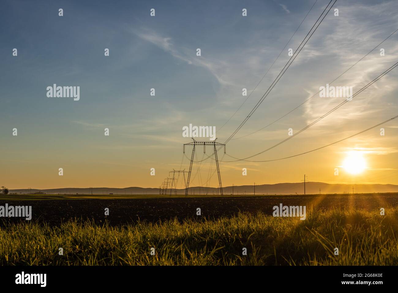 High voltage electric transmission towers and power lines at sunset ...