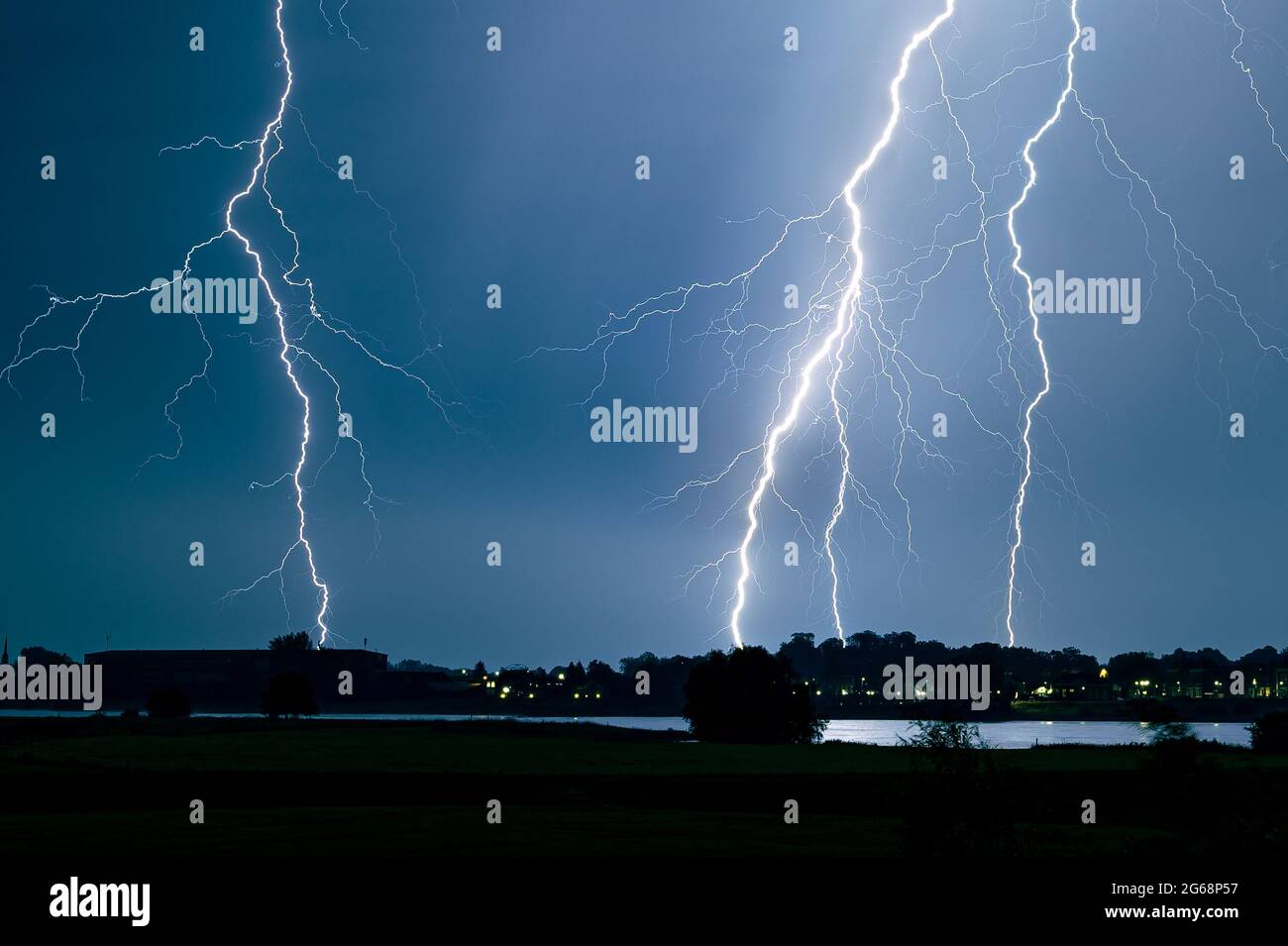 Branched lightning strikes close to a river Stock Photo Alamy