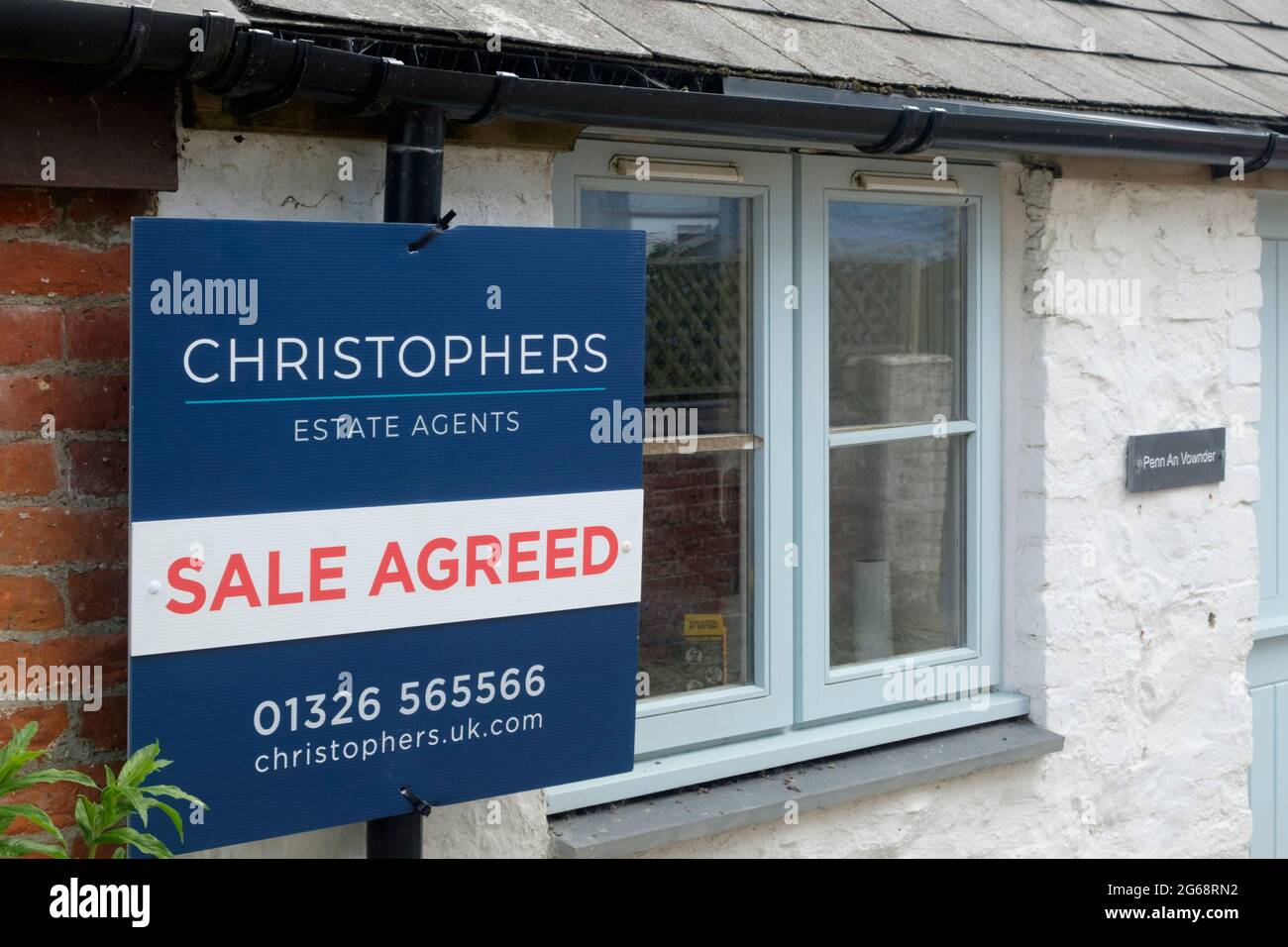 Estate Agent for Sale sign utside a cottage in Lizard Village, cornwall, UK. Stock Photo