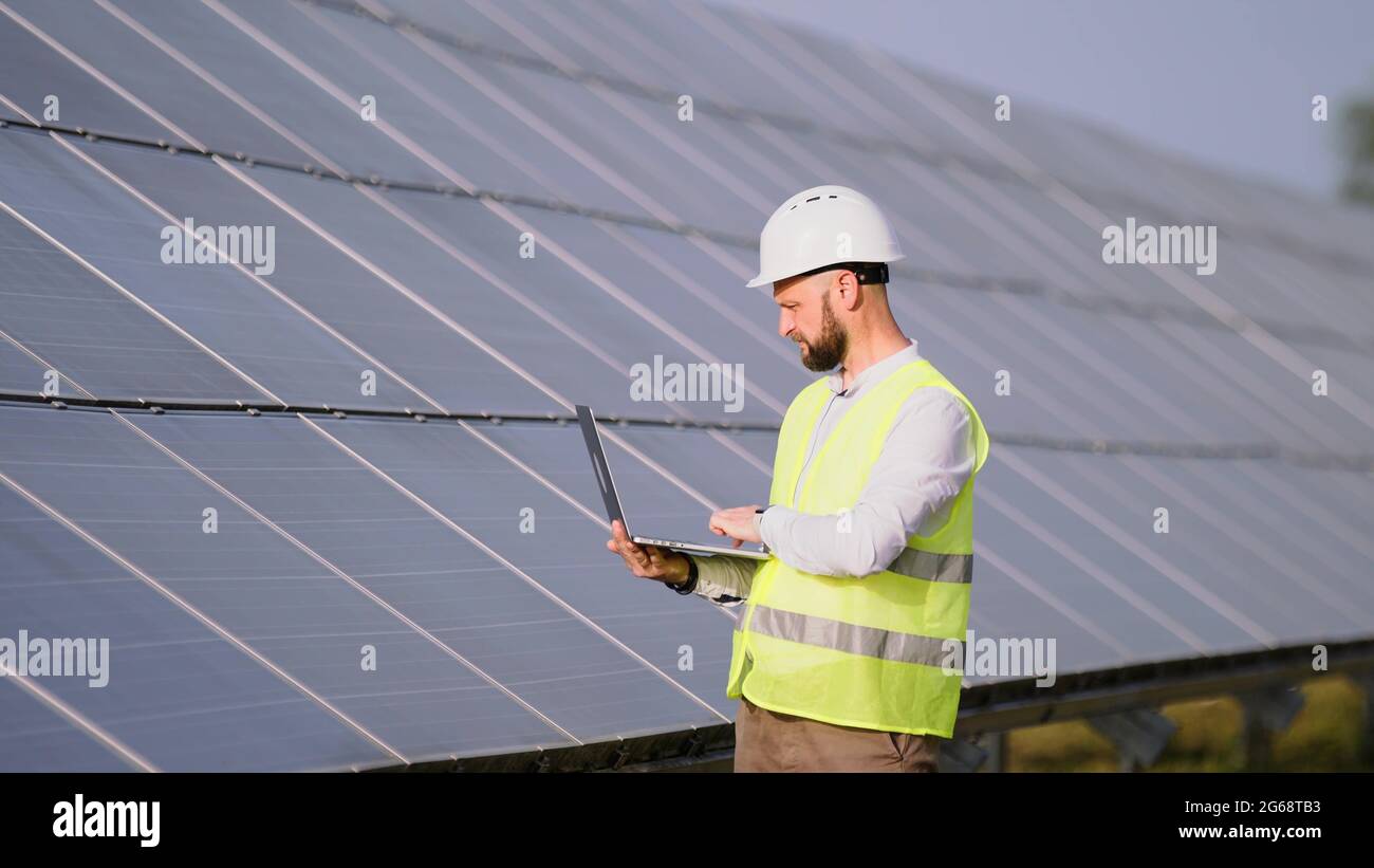 Engineer working use laptop stand near solar batteries construction