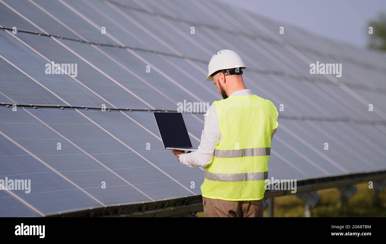 Engineer working use laptop stand near solar batteries construction ...