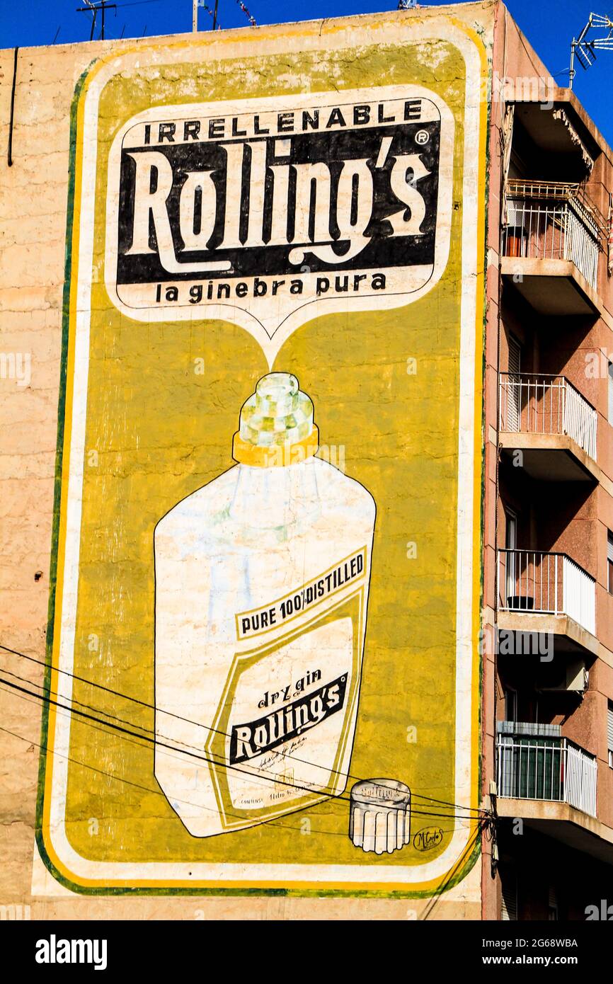 Elche, Alicante, Spain- February 27, 2021: Retro advertising sign for the Rolling's gin brand on a building wall of Elche, Alicante, Spain Stock Photo