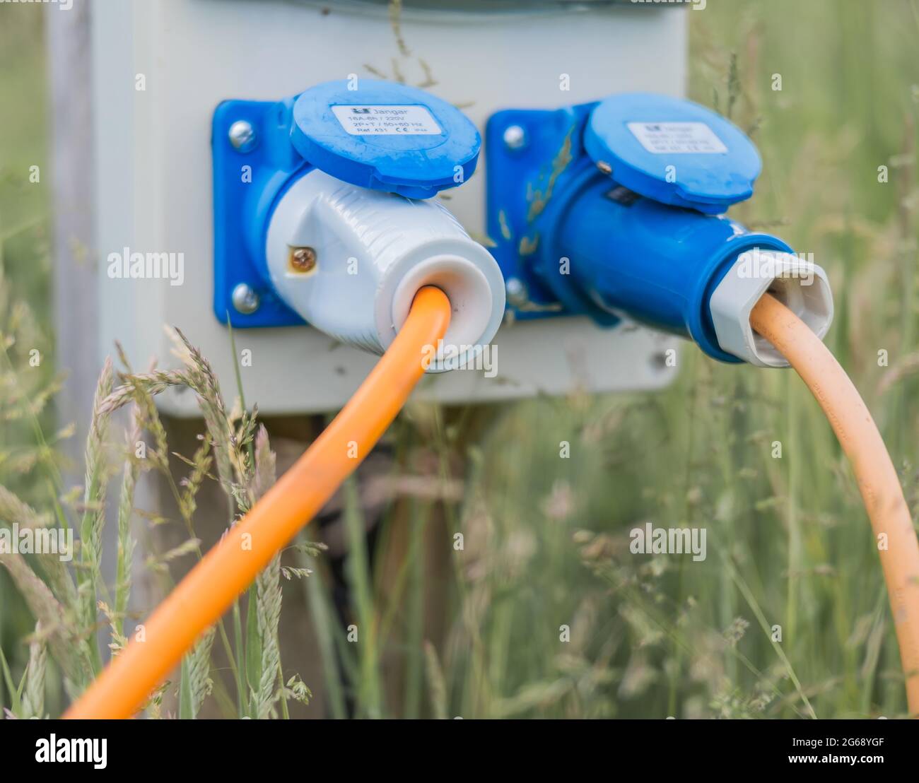 Electric hook up plugs inserted in to socket on a campsite Stock Photo