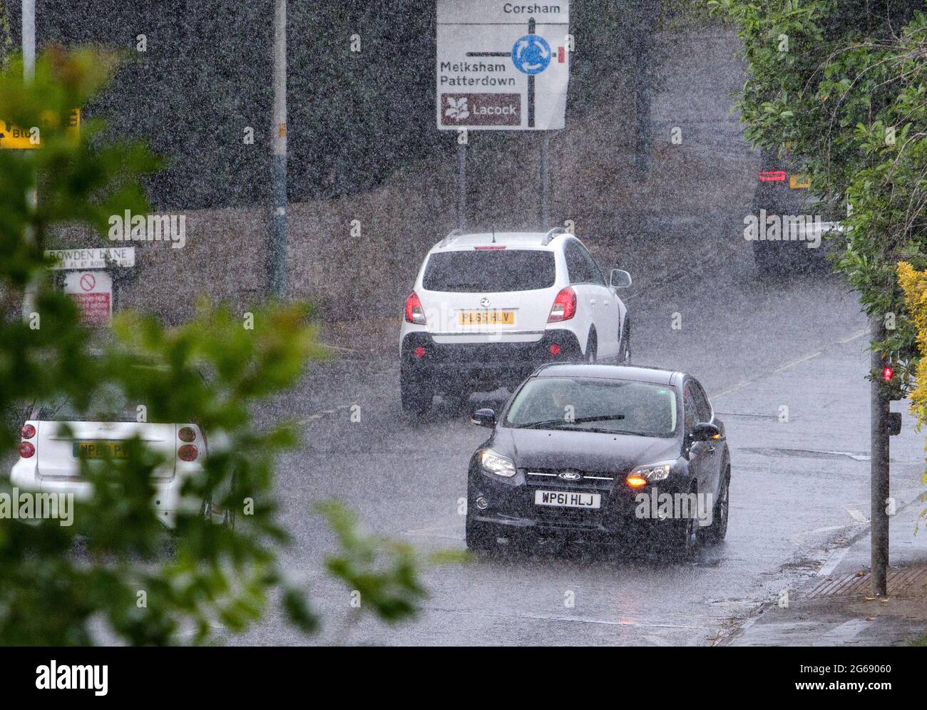 Chippenham, Wiltshire, UK. 4th July, 2021. Car drivers are pictured braving heavy rain in Chippenham as heavy rain showers make their way across Southern England. Credit: Lynchpics/Alamy Live News Stock Photo