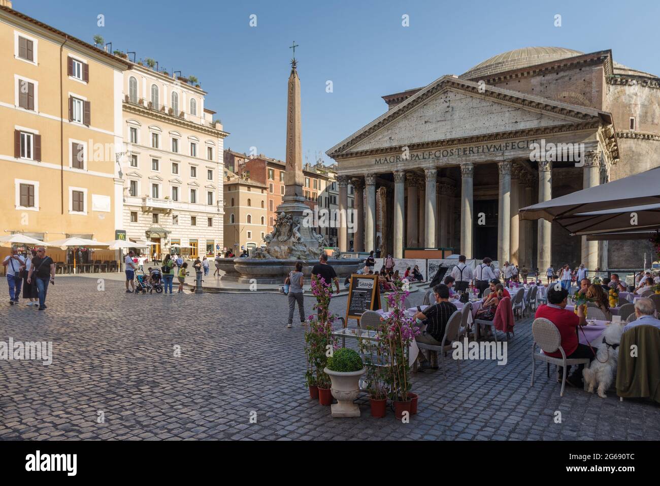 Pantheon square also known as Piazza della Rotonda with the Fountain and obelisk. Tourists in outside restaurant Stock Photo
