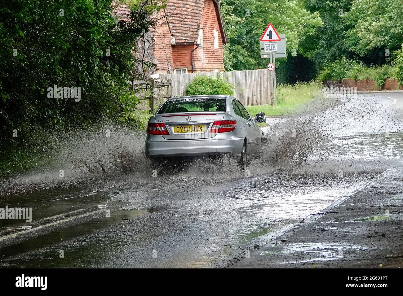 Car driving fast through flood water hi-res stock photography and