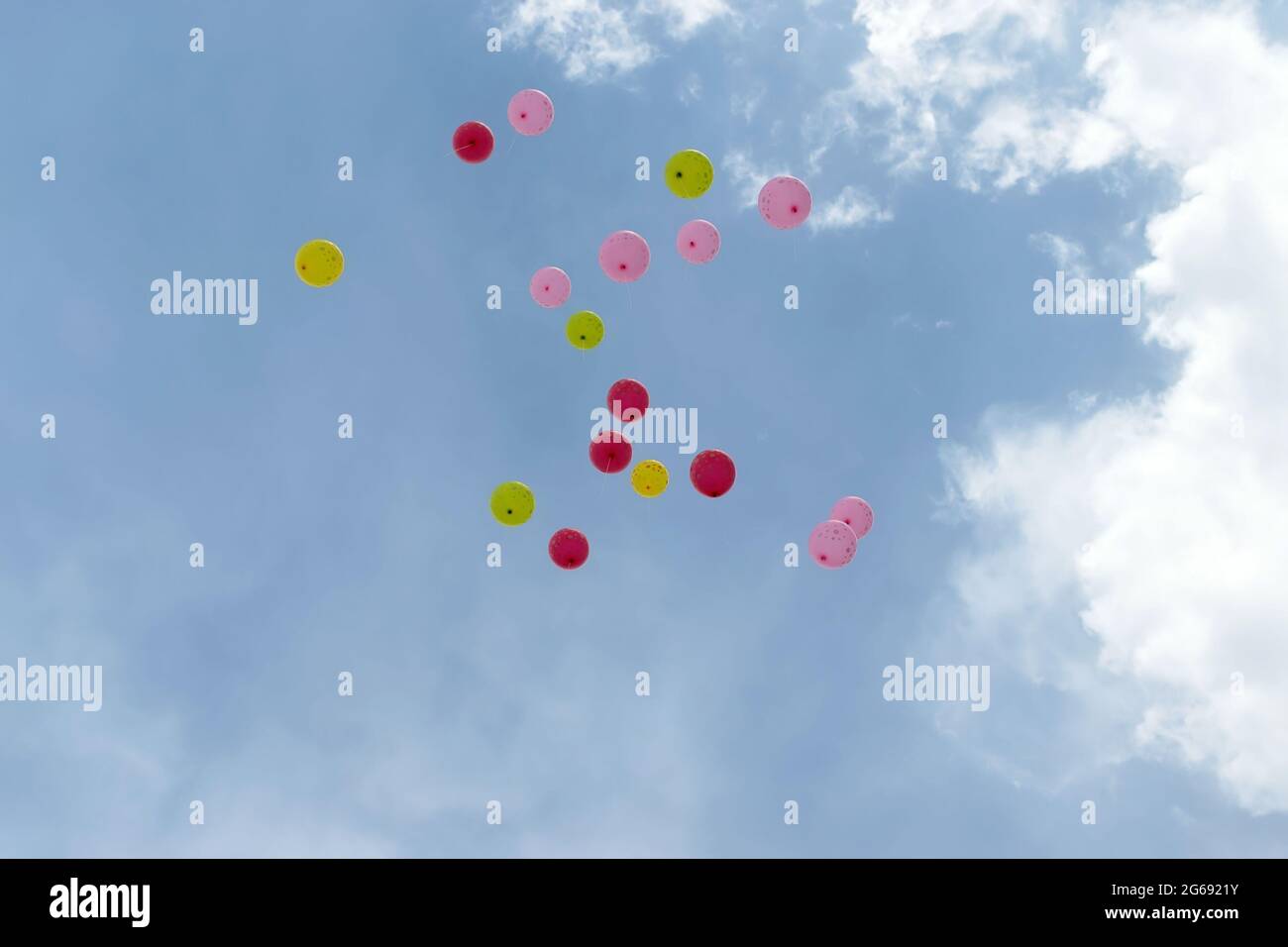 Many colorful balloons are flying in the sky against the background of clouds Stock Photo