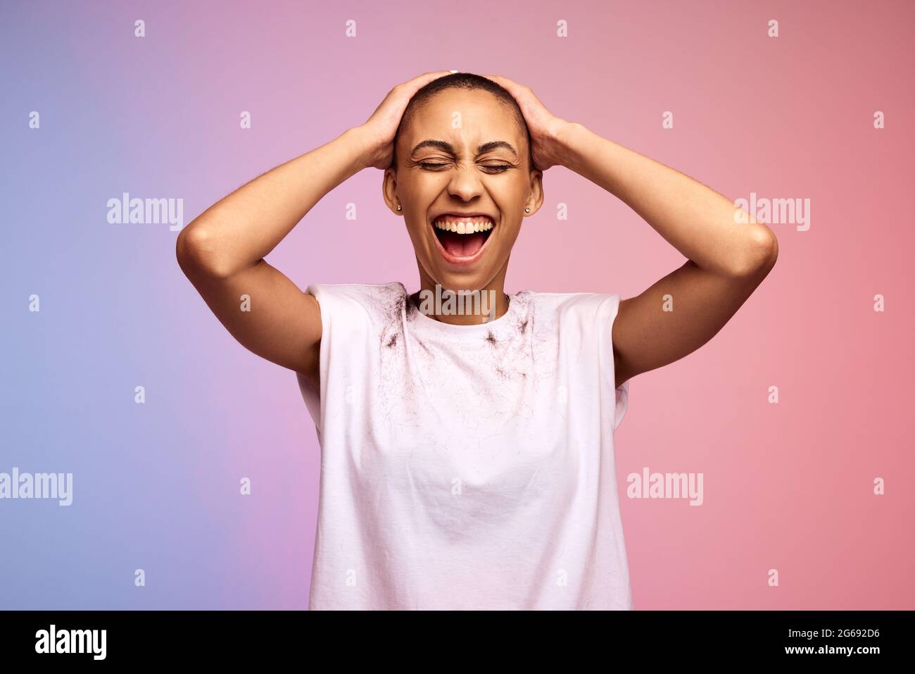 Happy woman with shaved head on gradient background. Confident and liberated female with short hair. Stock Photo