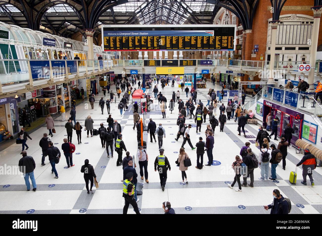 People passengers walking on the concourse and checking departure times at Liverpool Street Station during covid pandemic in London UK KATHY DEWITT Stock Photo