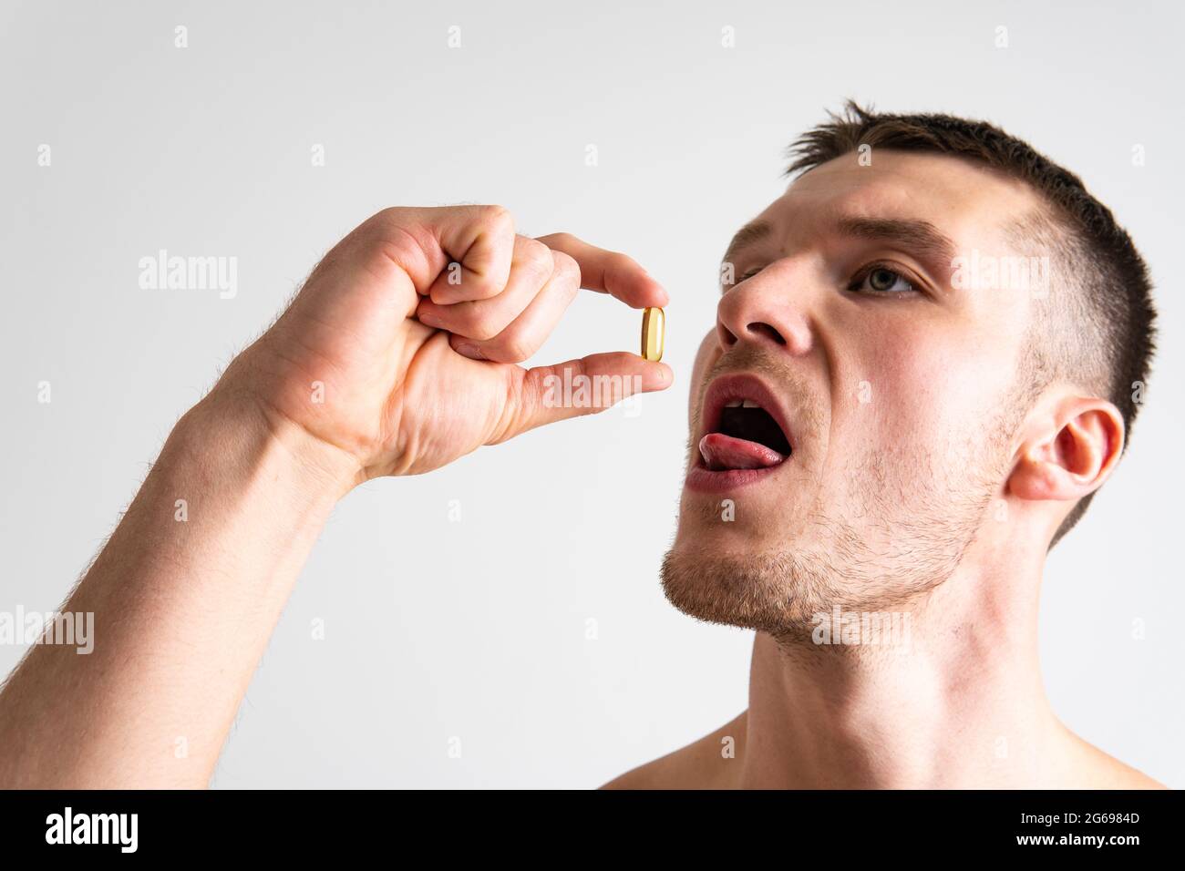 Fish oil is eaten by a man in the hands of vials and a glass bottle pill man nutrition drug cure care, closeup. Hand isolated taking, omega3 female gi Stock Photo