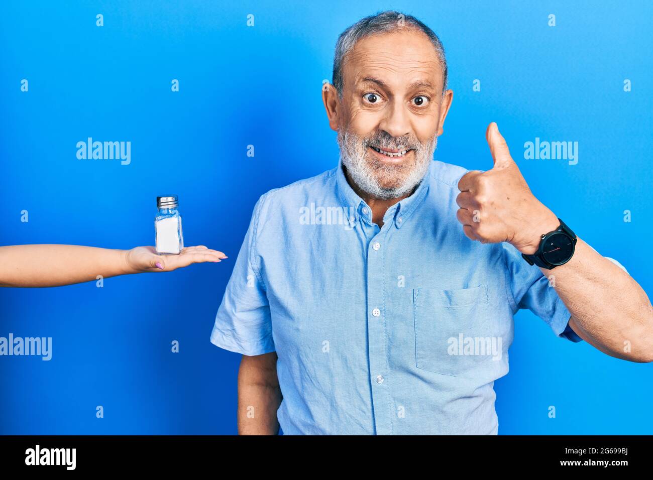 Handsome senior man with beard being offering salt smiling happy and ...