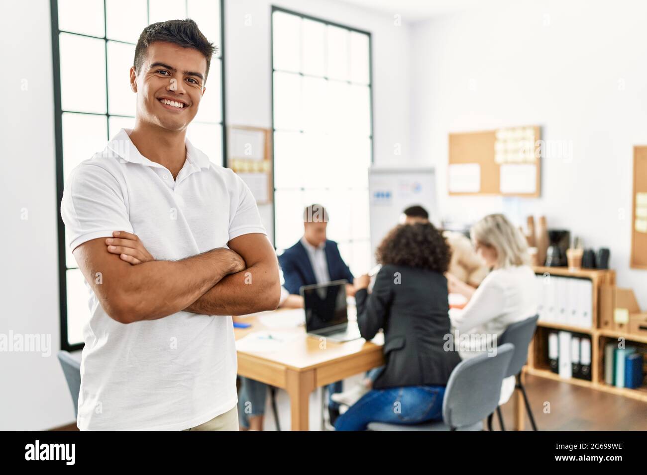 Young hispanic businessman smiling happy standing with arms crossed ...