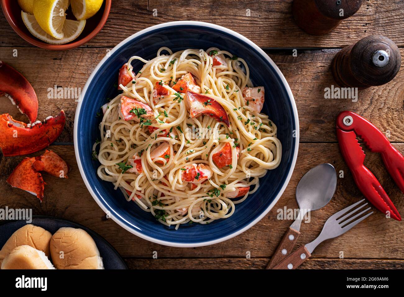 A plate of delicious lobster linguine on a rustic wood table top. Stock Photo