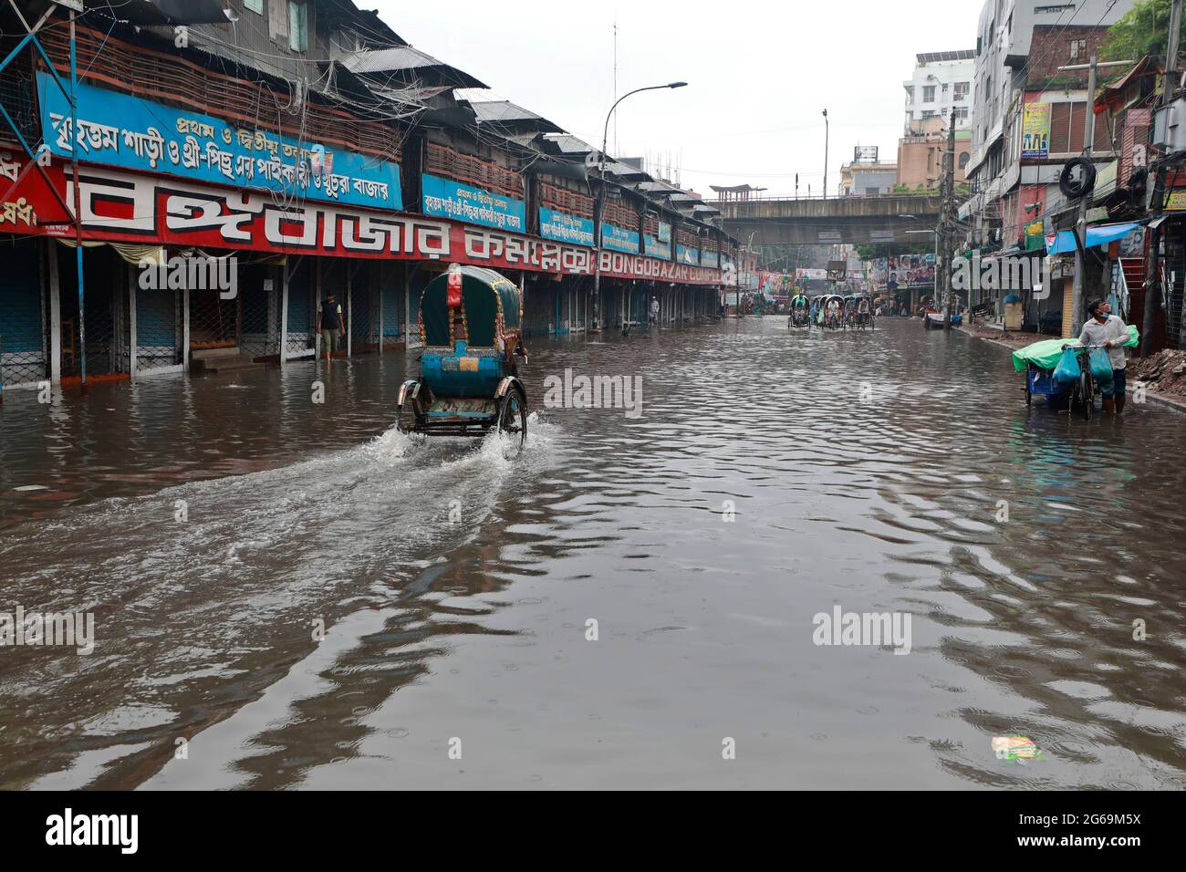 Dhaka, Bangladesh - July 04, 2021: Vehicles try to drive through a flooded street in Dhaka, Bangladesh. Encroachment of canals is contributing to the Stock Photo