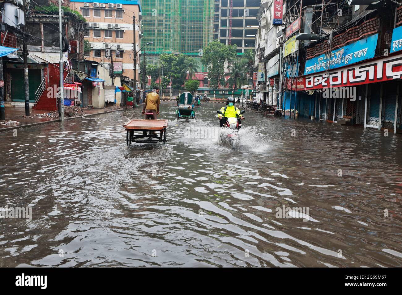 Dhaka, Bangladesh - July 04, 2021: Vehicles try to drive through a flooded street in Dhaka, Bangladesh. Encroachment of canals is contributing to the Stock Photo