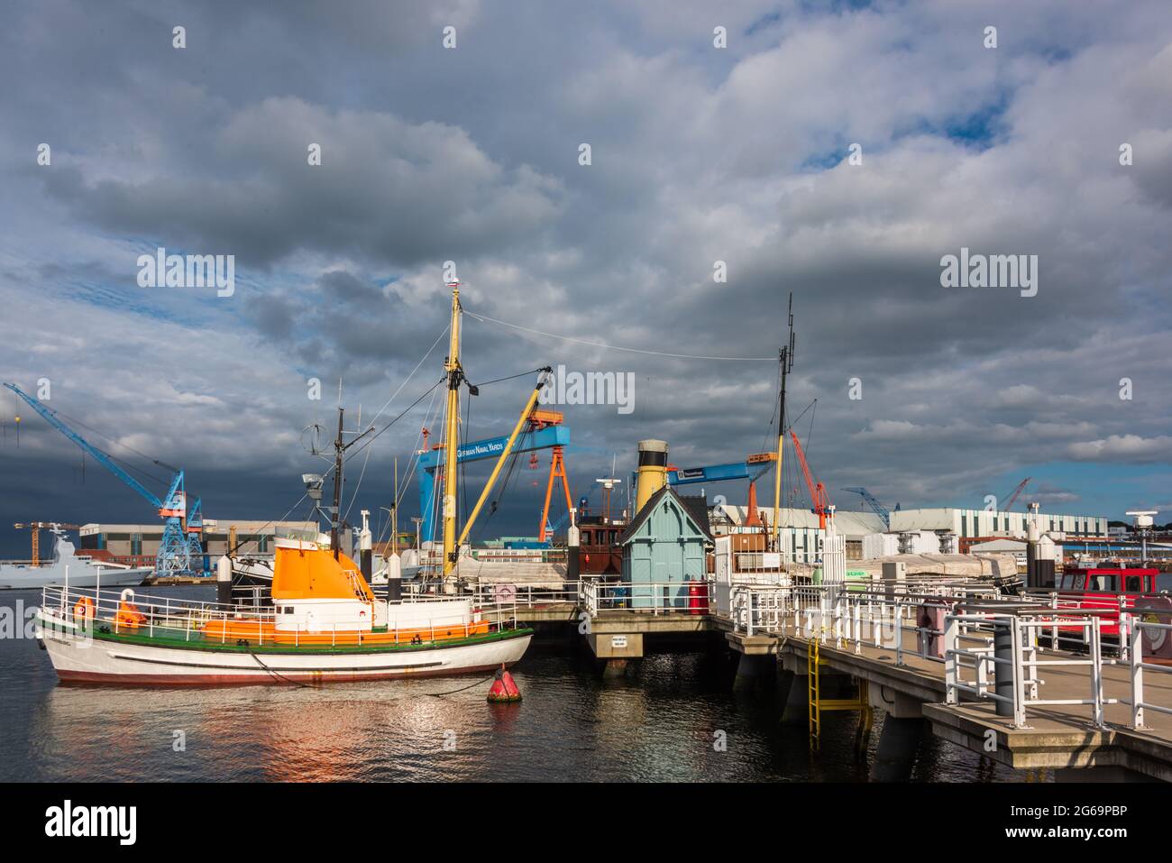 Kiel, der Museumshafen mit historischen Schiffen, Die Werftanlagen von Kiel-Gaarden im Hintergrund Stock Photo