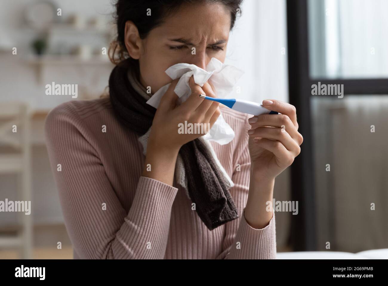 Unhappy young hispanic woman feeling grippe disease. Stock Photo