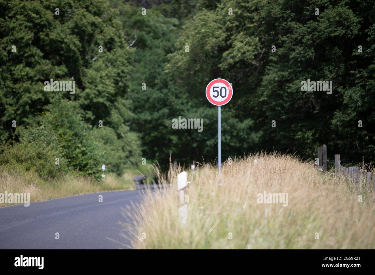 German road sign zone 50 km / h in a rural area, cloudy sky Stock Photo